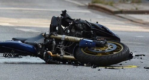 A crashed motorcycle laying on the road.