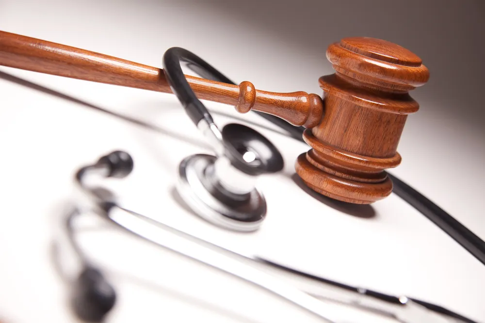 Gavel and stethoscope entwined together.