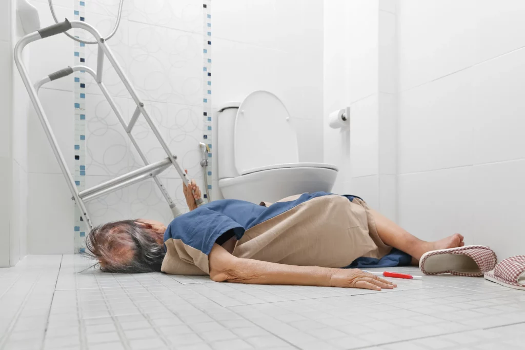 Elderly person laying on the bathroom floor after a fall. If your loved one is being neglected in a nursing home, contact a nursing home abuse attorney now.