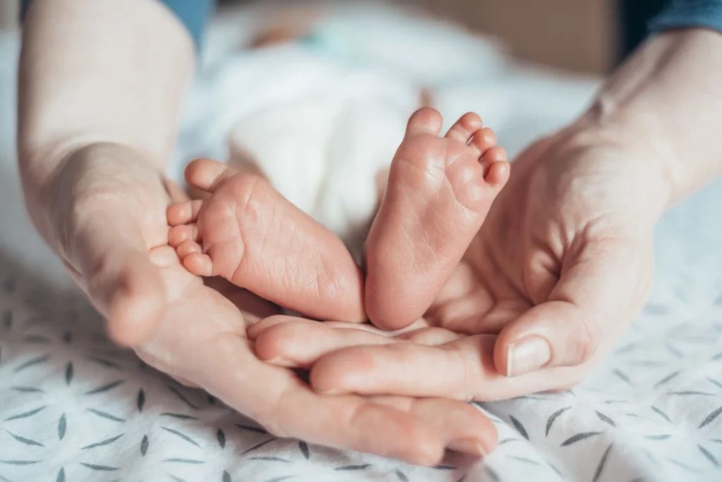Mother holding newborn baby’s feet. If you or your newborn have sustained an injury at birth, our birth injury lawyers are ready to help you.