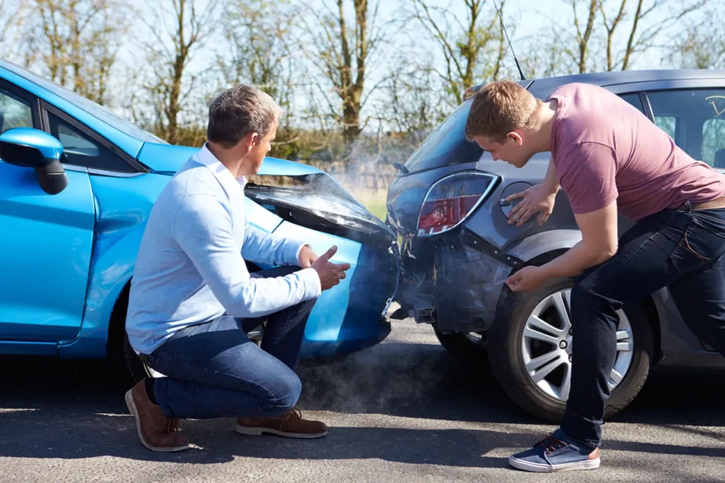 Two men observing their cars after a car accident. Our Kansas City personal injury lawyers will defend you if you've been injured in a motor vehicle accident. 